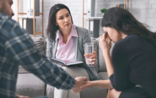 certified addiction counselor offering glass of water to addiction abuse patient
